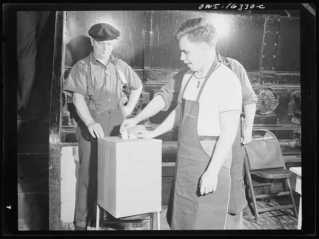 worker puts ballot in ballot box